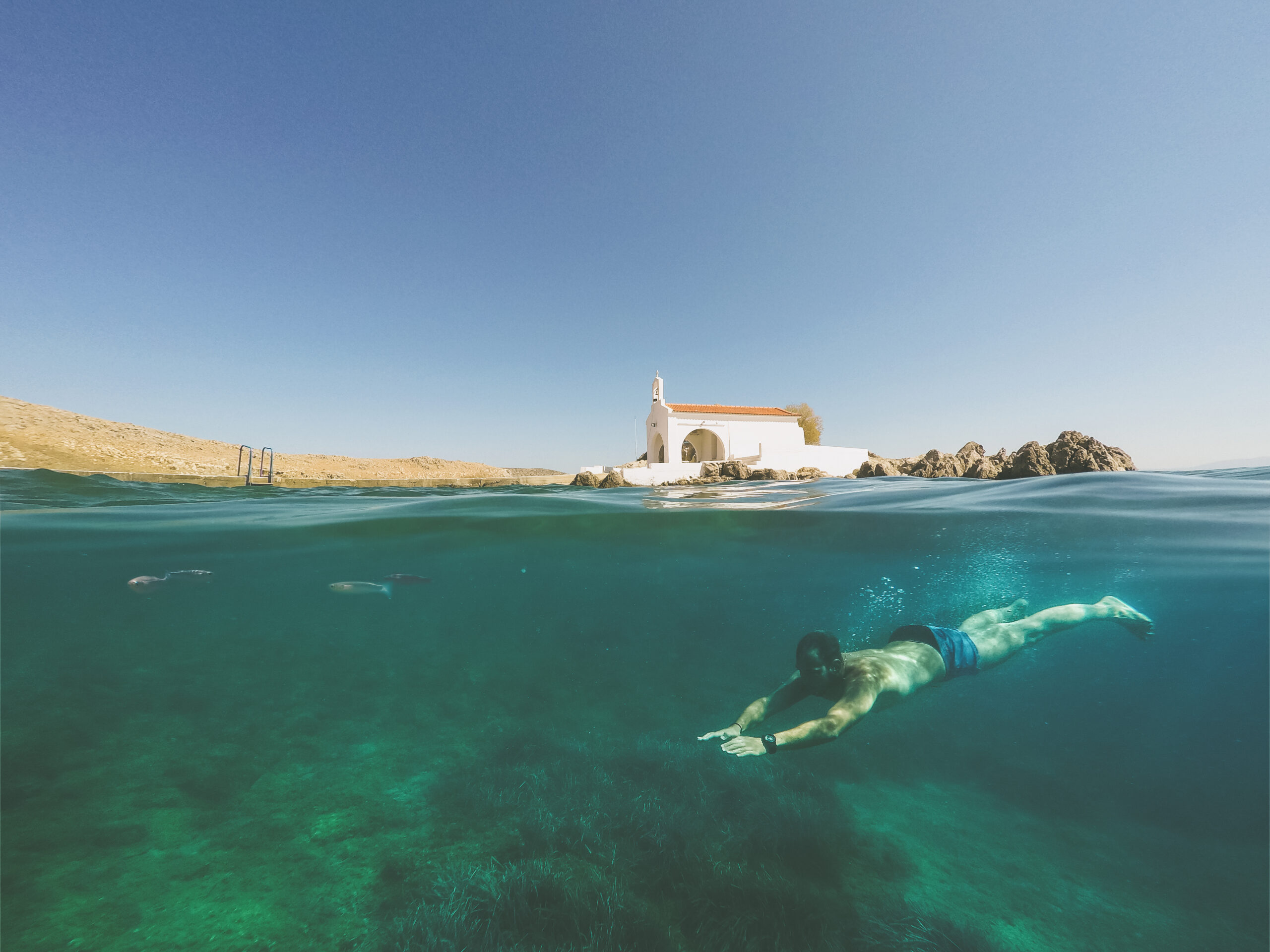 half,underwater,shot,of,a,man,freedives,below,the,surface