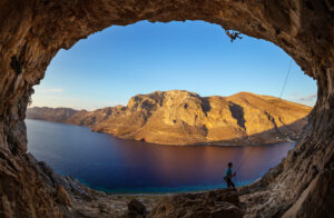 male,rock,climber,on,challenging,route,in,cave,,his,partner